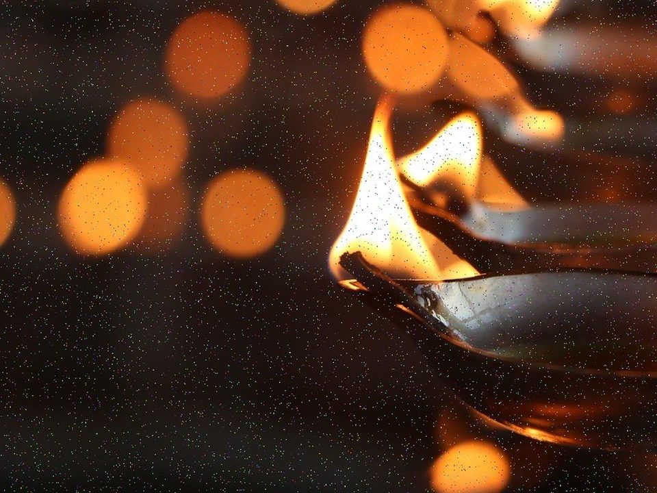 Two candles burning in a dark room