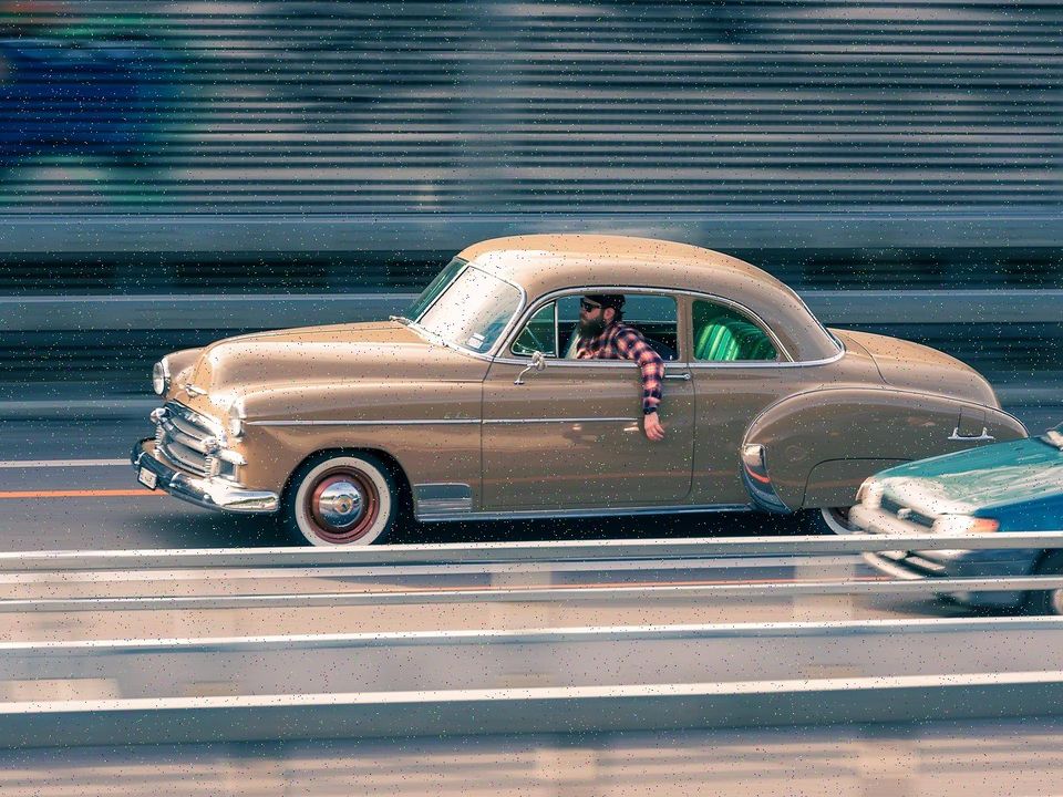 A vintage car moving past in a blur