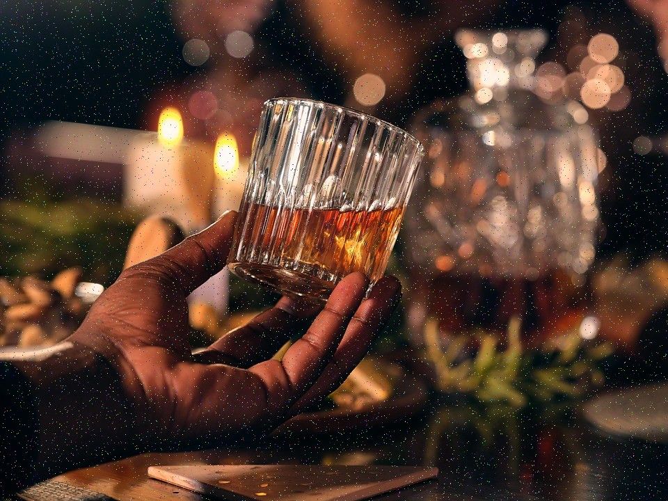 Hands holding a glass by candlelight