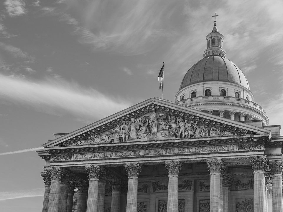 A domed stone building with classical columns in black and white